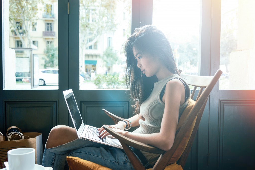 young girl using laptop at a coffee shop