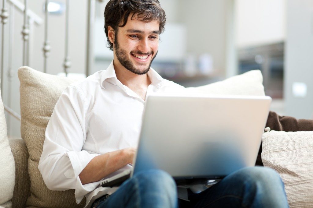 Man using his laptop while sitting on the couch