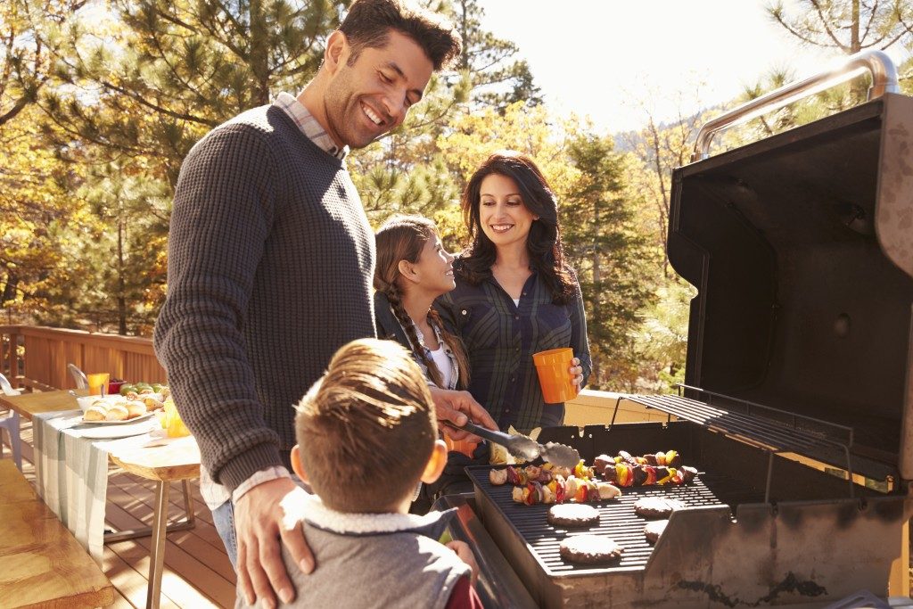 Whole family grilling barbecue