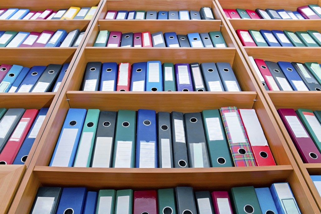 File folders, standing on the shelves in the background