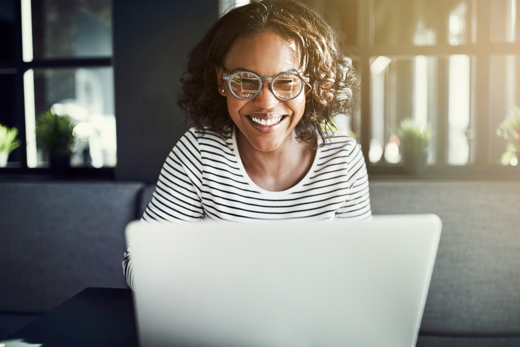 Woman writing a journal in her laptop 