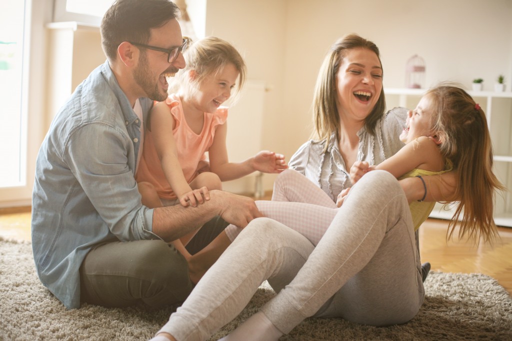 Mom and dad playing with their little girls