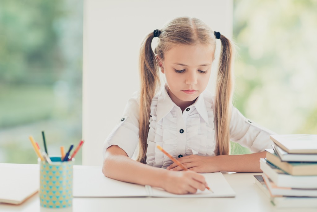 little girl writing on her notebook