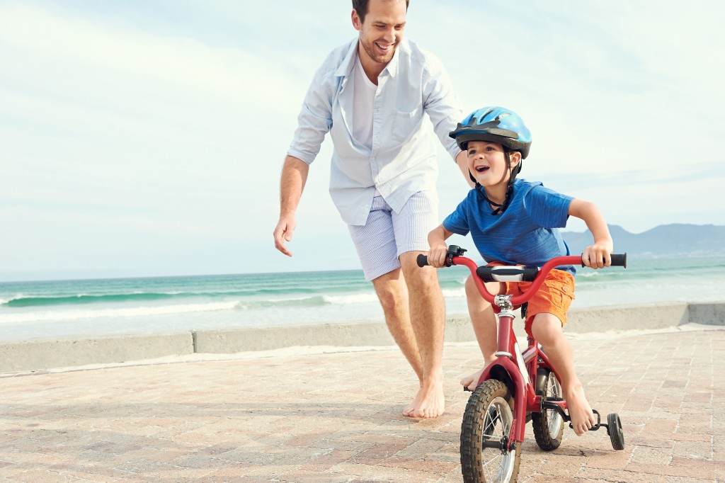 Father and son learning to ride a bicycle