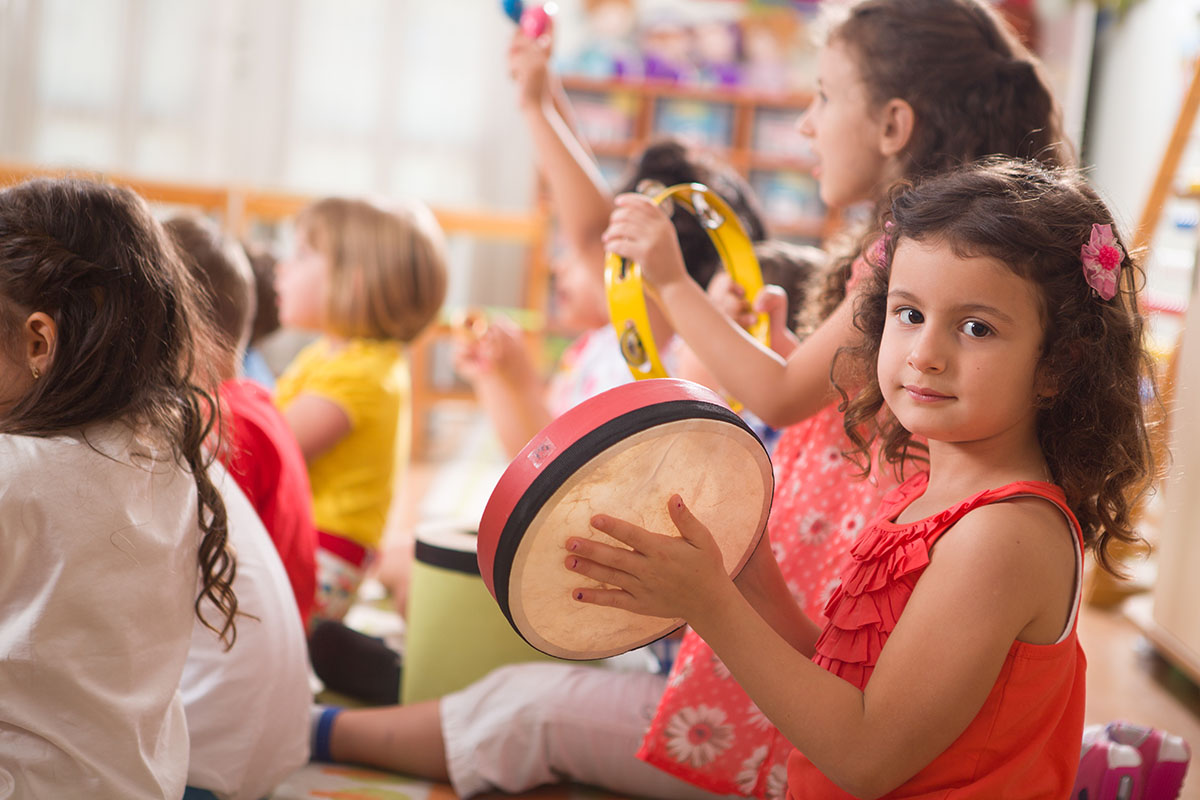 little girl playing the tambourine