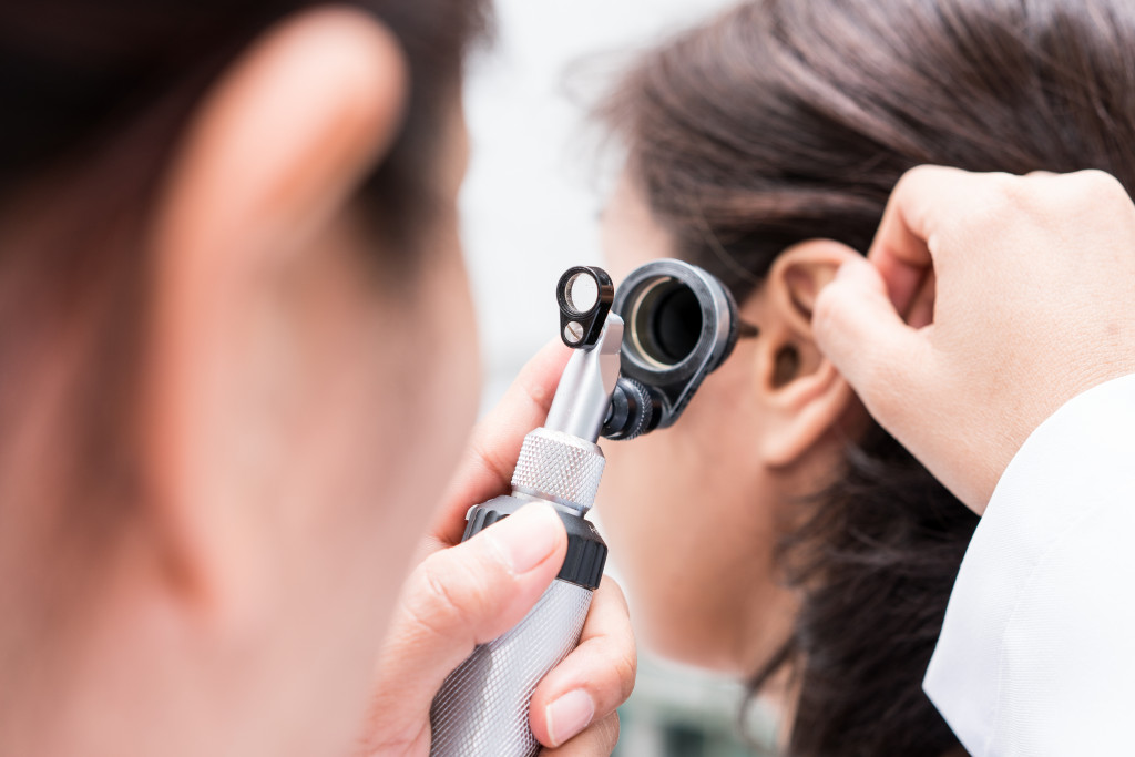 doctor examining an ear using a tool