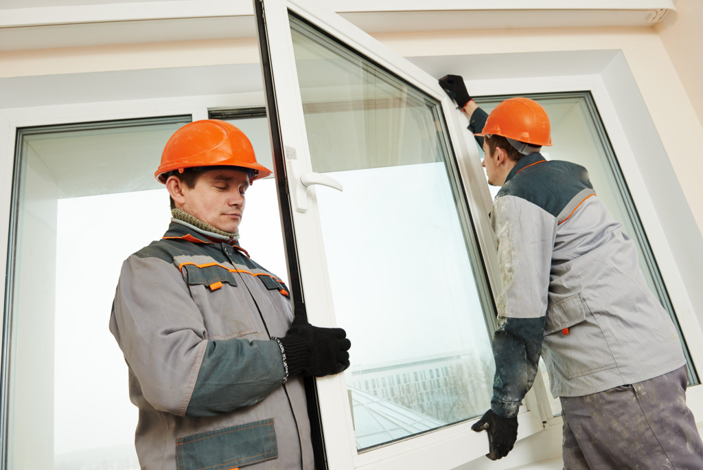 contractors installing a window panel