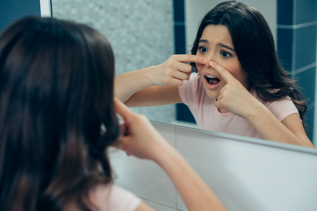 woman popping her pimple