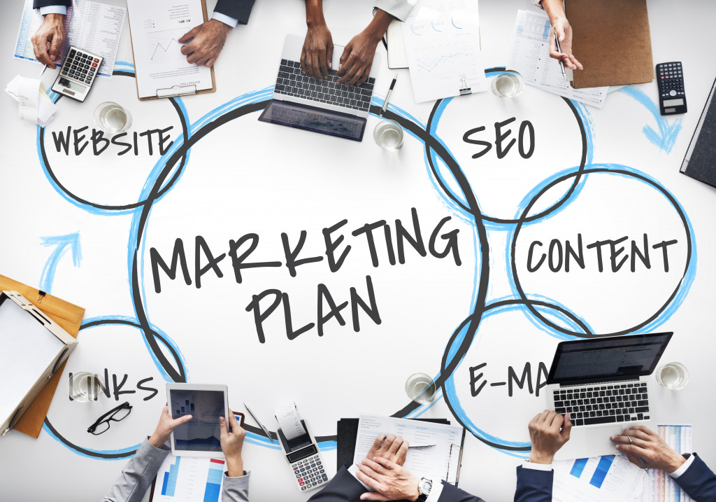 marketing plan written on a desk with employees around it