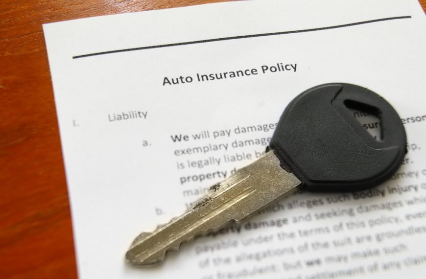 Closeup of a car key on an auto insurance policy