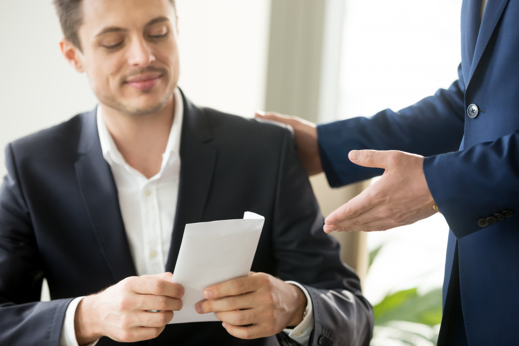 an employee holding an envelope from boss