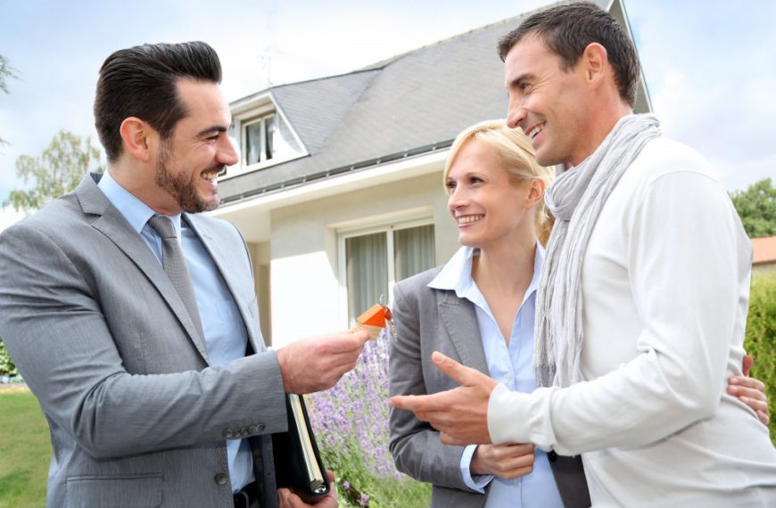 Salesman giving home keys to property owners