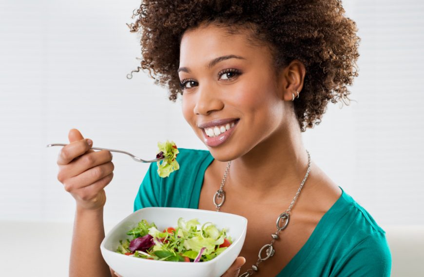 Close-up Of Beautiful African American Woman Eating Salad At Home