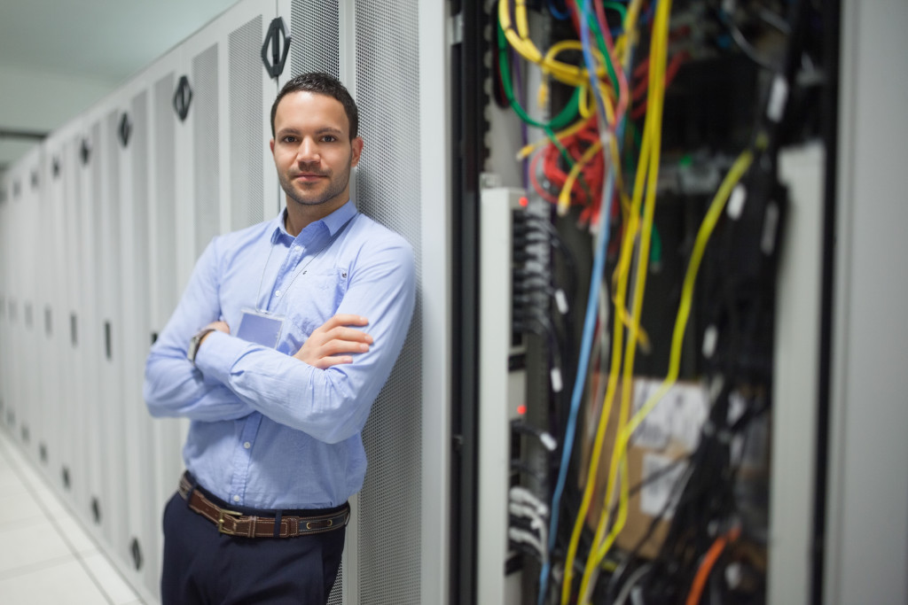 a portrait of a businessman standing in a server room