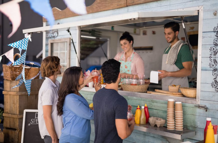 Smiling waiter taking order from customer at counter