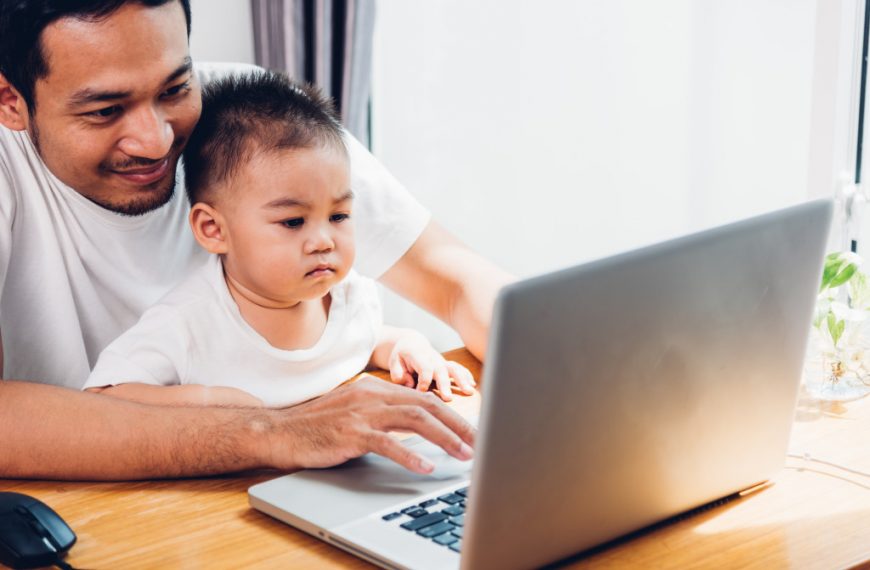 son sitting in his father's lap while he is working