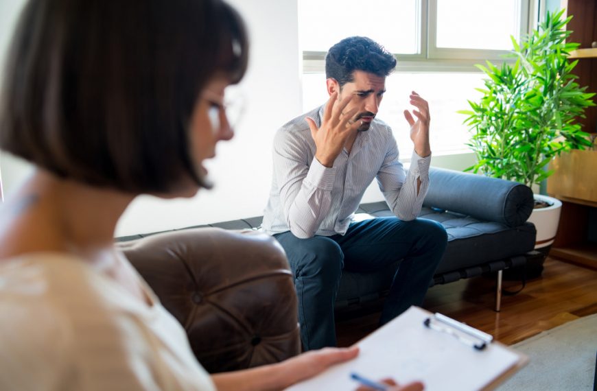 Psychologist taking notes during therapy session.