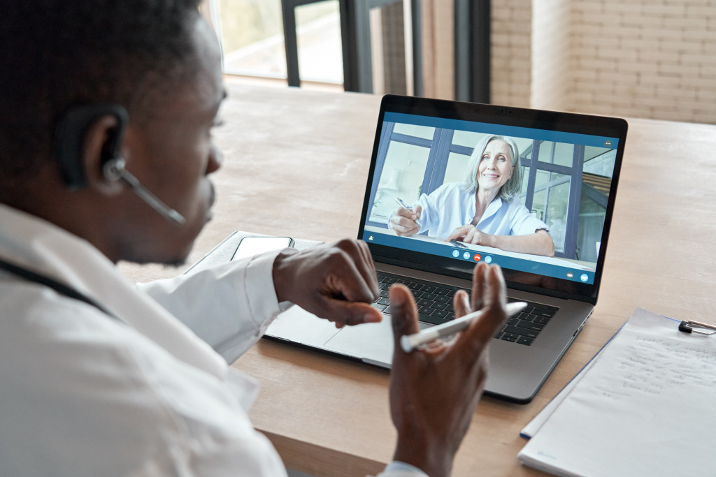 Portrait of a doctor talking with his patient on a video call at home