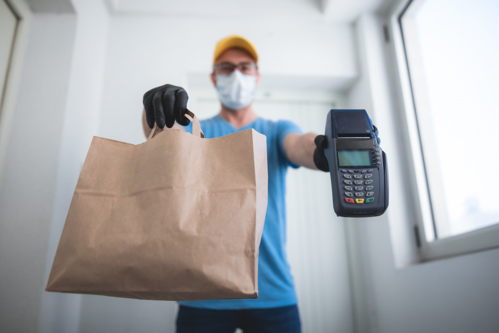 A man delivering food with credit card payment