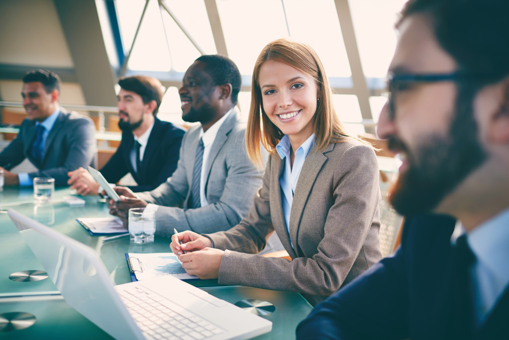 row of business people in meeting or presentation with smiling woman