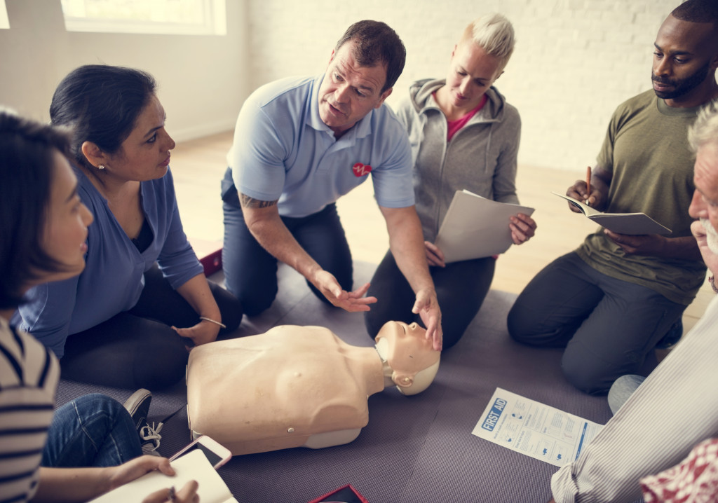 A professional training a group of people about CPR, first aid