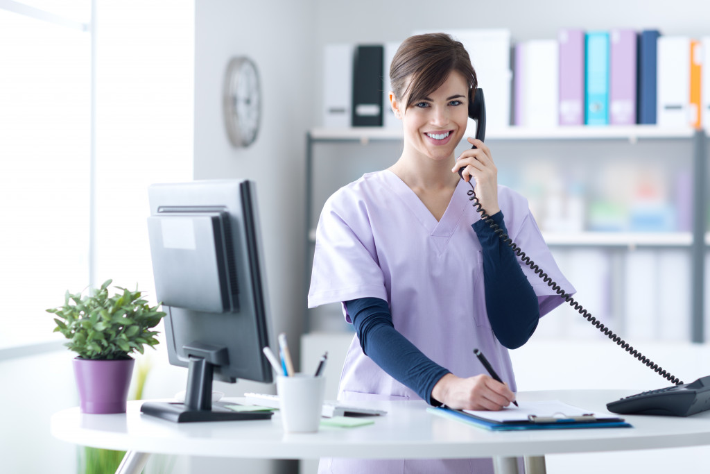 A receptionist at a medical clinic taking a call