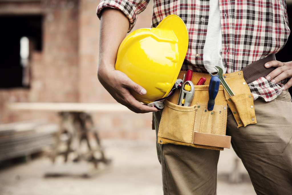 a construction worker holding a safety helmet