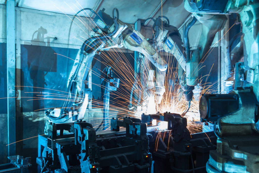 Welding robots putting together parts in a factory.