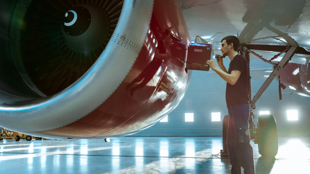 a man installing a spare part on an aircraft