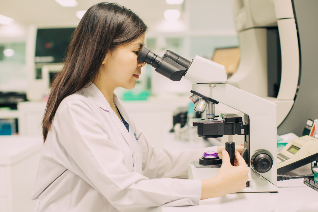 A medical technologist looking into a microscope inside a laboratory