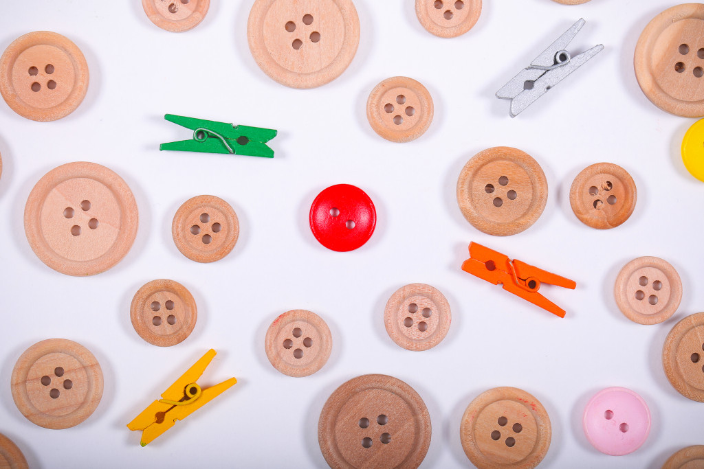 wooden buttons and clips in white background representing product customization