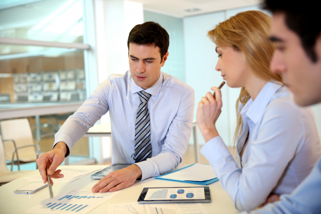 a corporate team reviewing business progress with graphs and figures