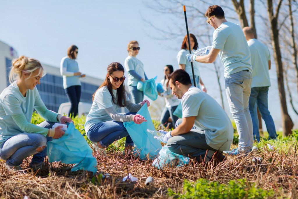 volunteer employees helping clean outdoors with blue tshirts on