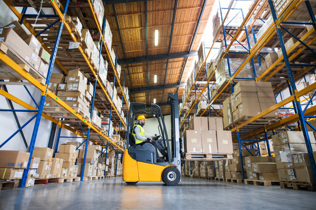 A man in the warehouse using a forklift