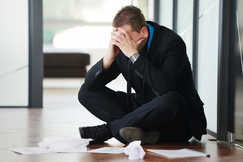 business owner sitting on the floor feeling depressed and lonely