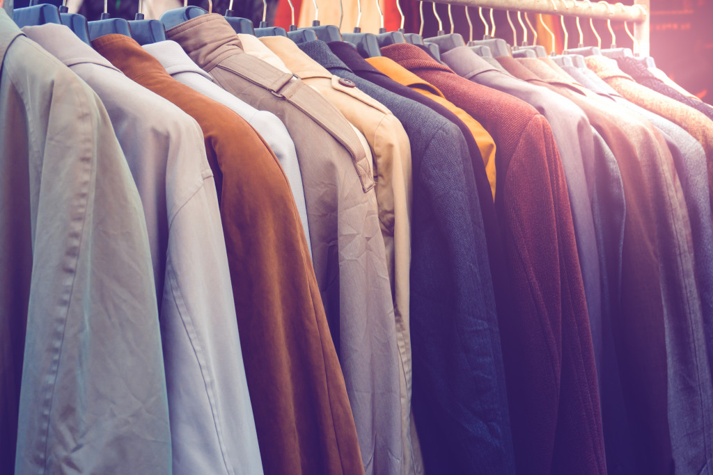 a row of suits of different colors in a wardrobe