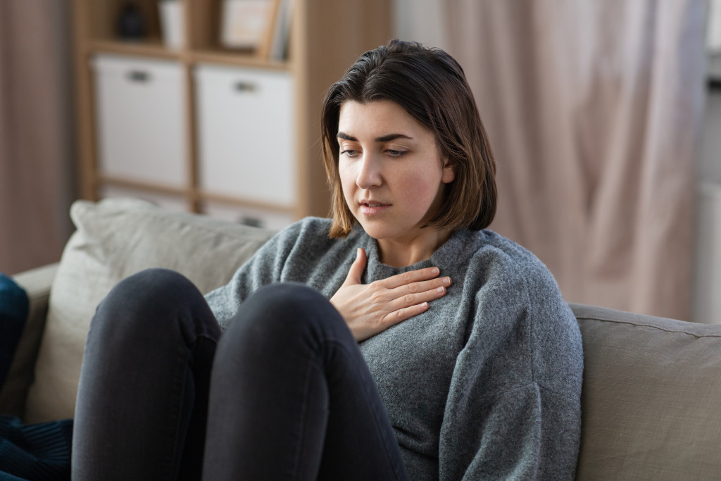 woman sitting in the sofa can't breath