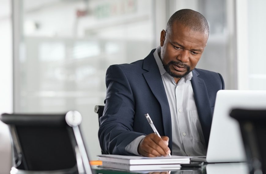 seriously working man boss in his office using laptop and notes