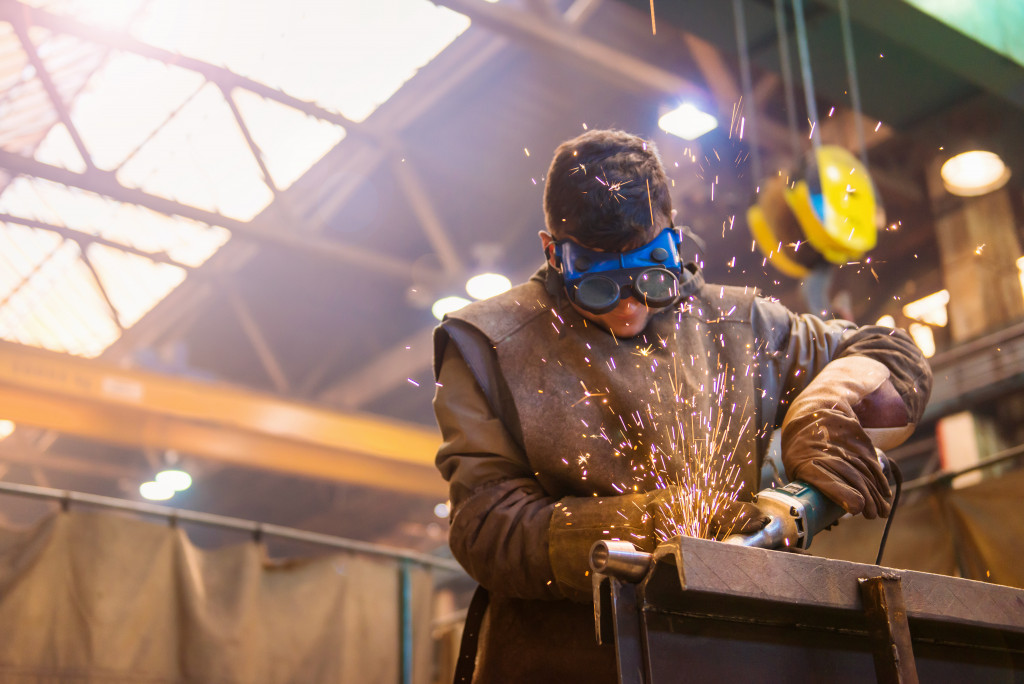 man with protective goggles welding in factory