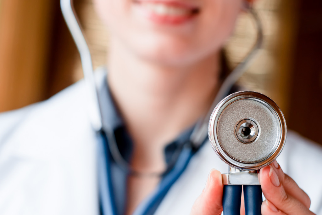 Female doctor holding up a stethoscope.