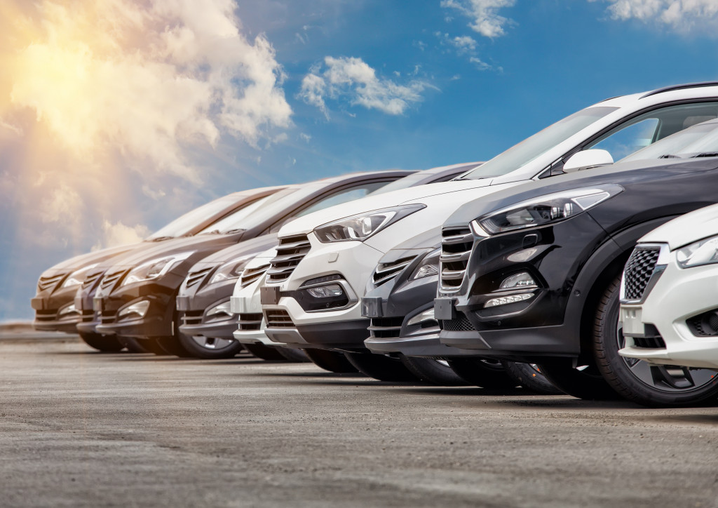 lineup of new cars glinting in the sun outdoors