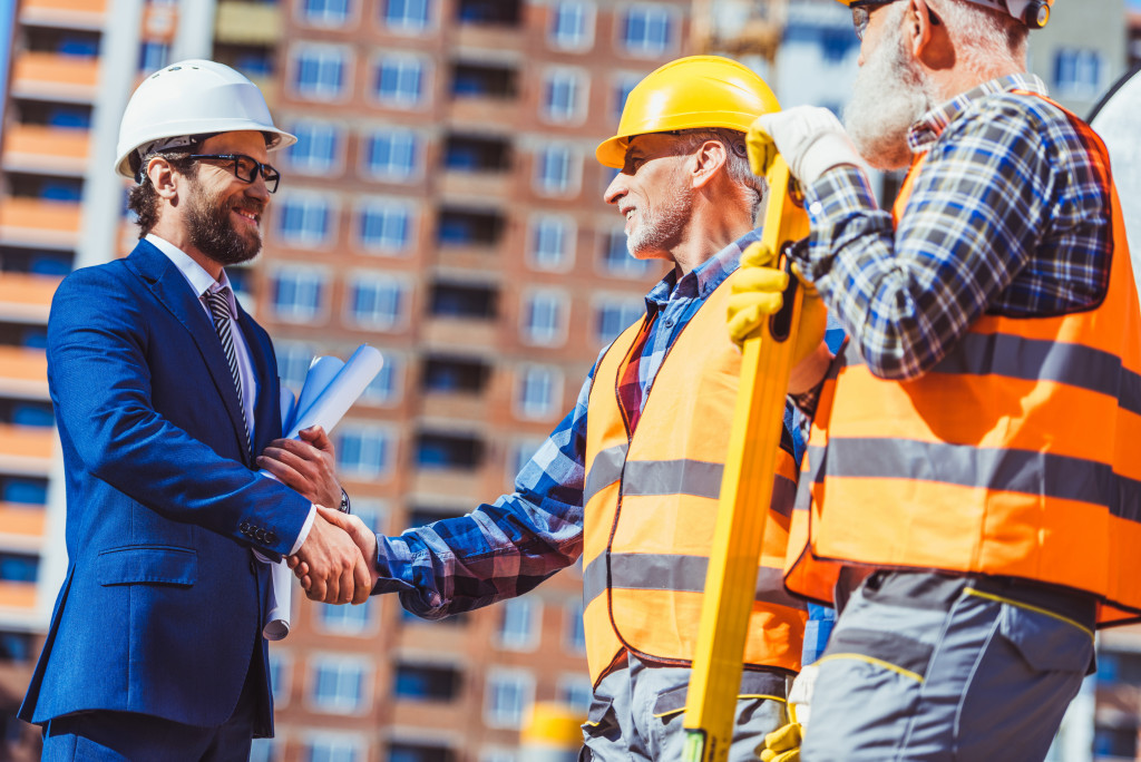 a man shaking hands with a construction team leader