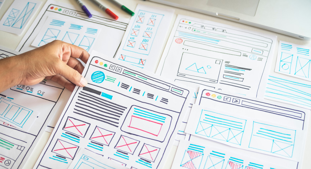 Designer creating a website layout on paper.