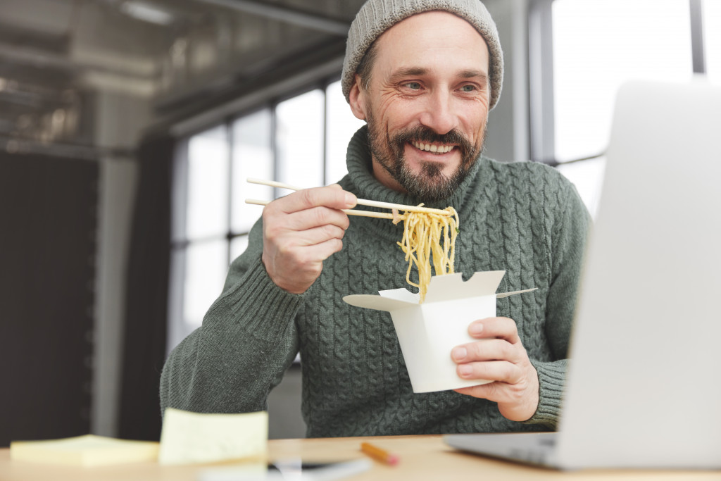 man at work eating unhealthy meal