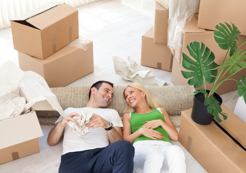 man and woman lying in the middle of cardboard boxes