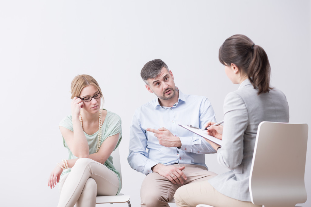 man pointing at his wife while in therapy