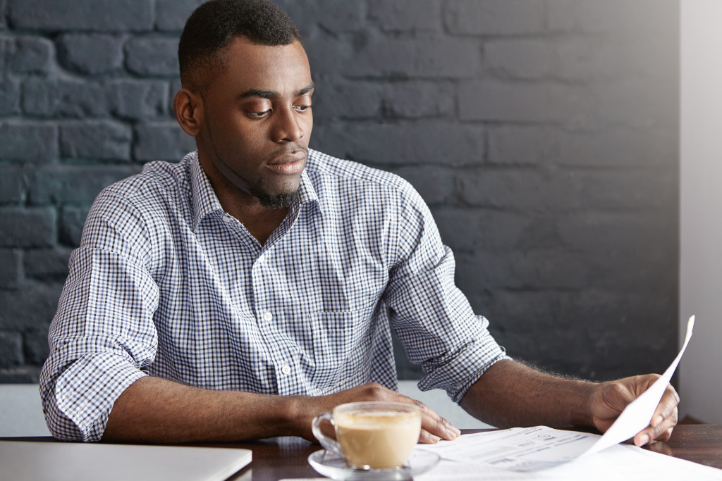 man at a cafe reading a document