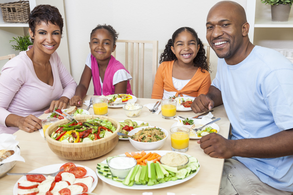 Family eating lunch consisting of fruits and vegetables at home.