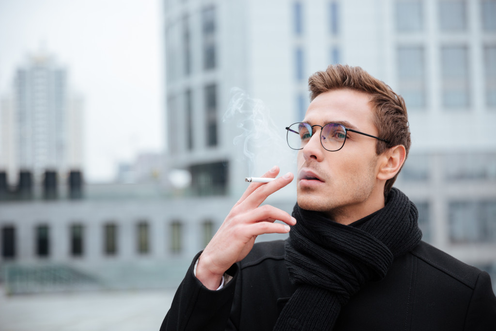 man smoking cigarette on the street