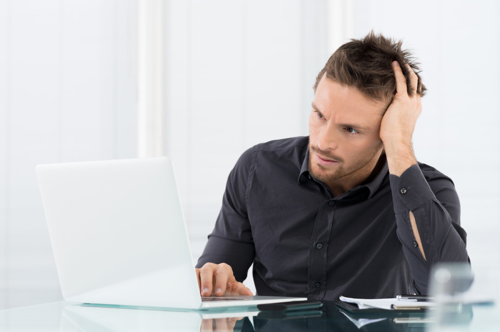 man on laptop looking stressed